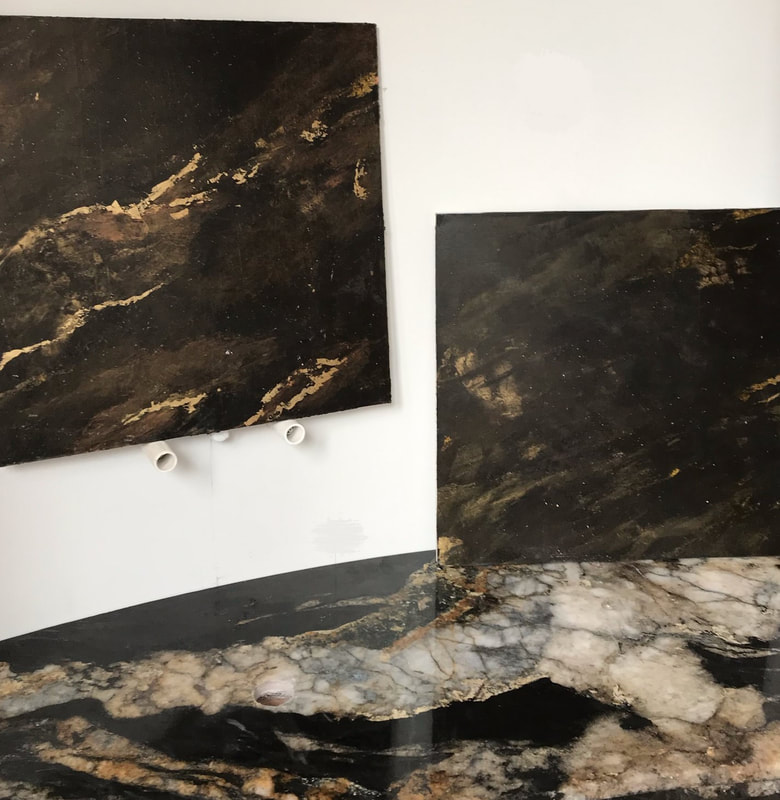 Black Venetian plaster sample with accents of gold and copper leaf and sealed with wax by Thompson Art Studios.