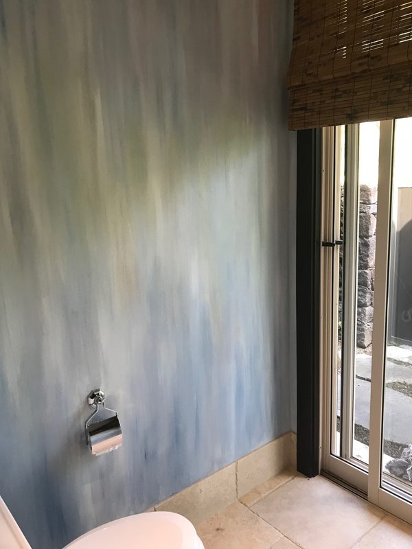 Thompson Art Studios painted the walls in this bathroom to simulate the movement of a waterfall through layers of color and brush stroke. 
